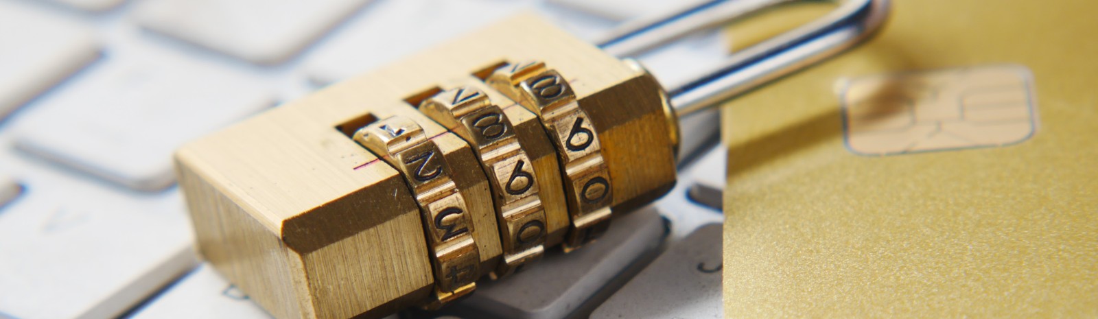 Lock with numbers sitting on keyboard next to debit card